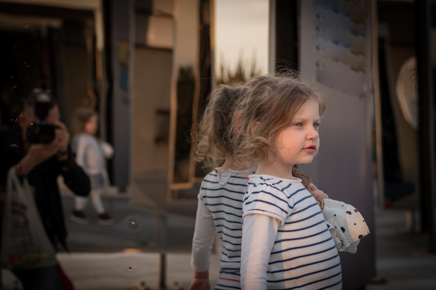 cute girl looking away while standing against glass window