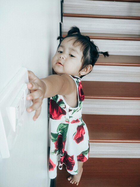 Photo cute girl looking away while standing at home