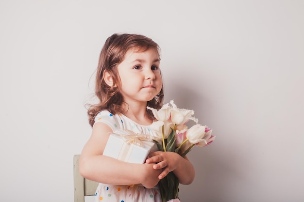白い背景の花を見ている可愛い女の子