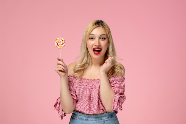 Photo cute girl lovely young lady with red lipstick in pink blouse excited holding pink lollipop