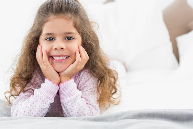 Photo cute girl lying on bed