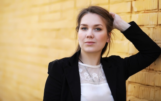 Cute girl near a brick wall in casual clothes