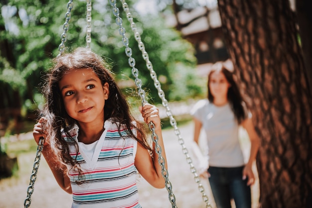 Cute Girl op Swing Mother Pushing Little Daughter