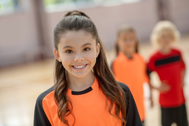 Cute girl in orange t-shirt smiling nicely