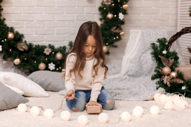 Cute girl packing Christmas gifts at home