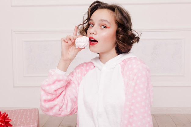 Cute girl in pajamas with sweets laying on the floor