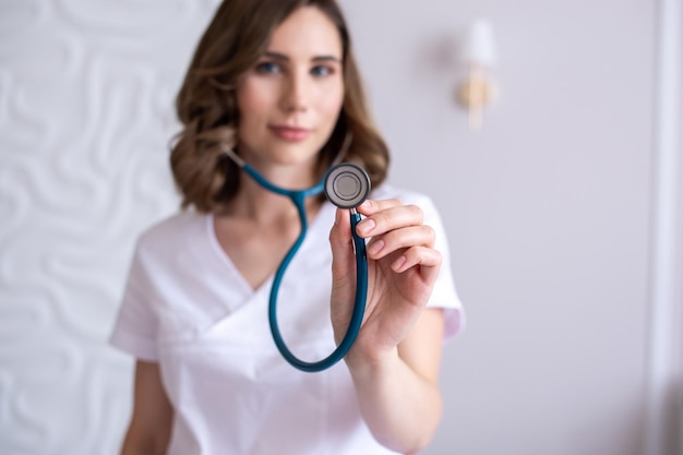 Cute girl pediatrician shows a stethoscope