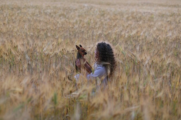 Cute girl playing with puppy  in field