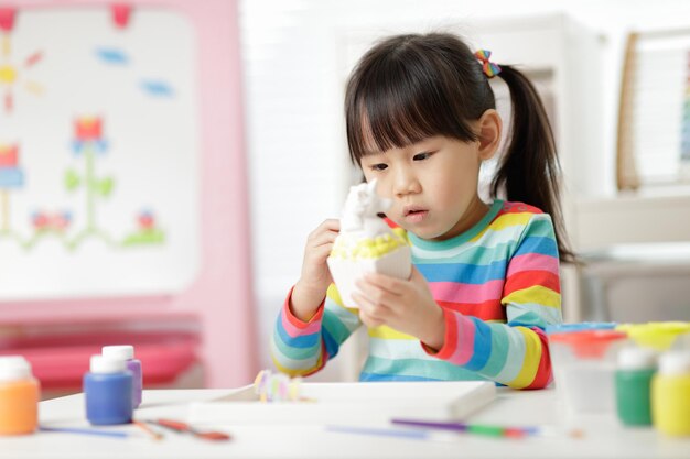 Cute girl playing with toy at classroom