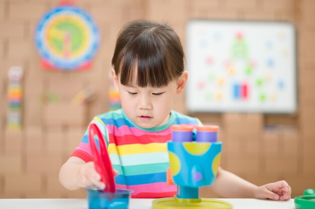 Cute girl playing with toy at home