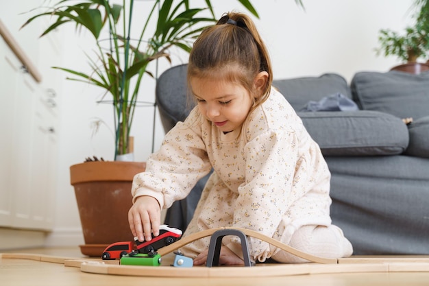 Photo cute girl playing with toy train