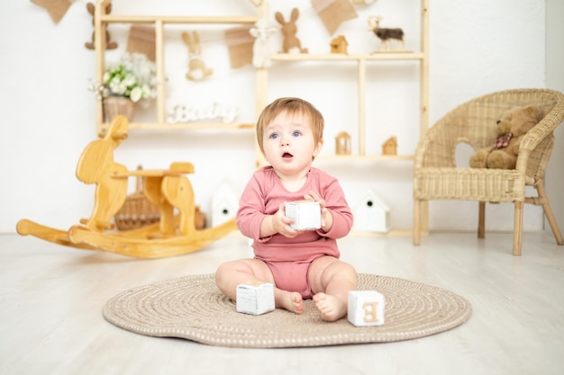 Cute girl playing with wooden natural toys in the children's room at home educational toys for children children's room interior