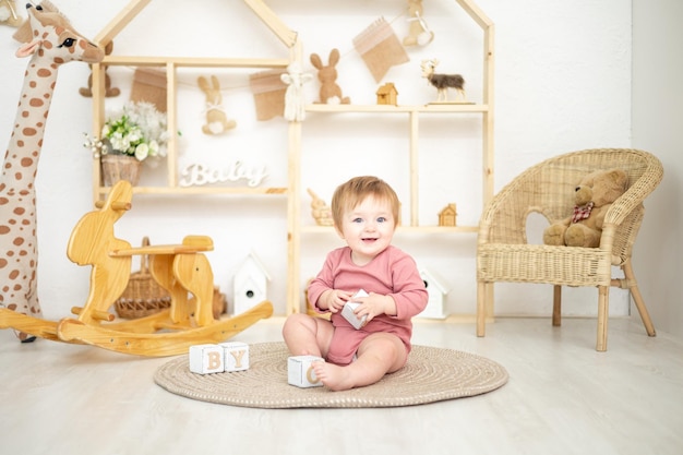 Cute girl playing with wooden natural toys in the children's room at home educational toys for children children's room interior