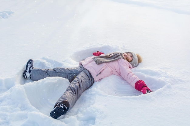 かわいい女の子は冬に雪で遊ぶ。冬の天使