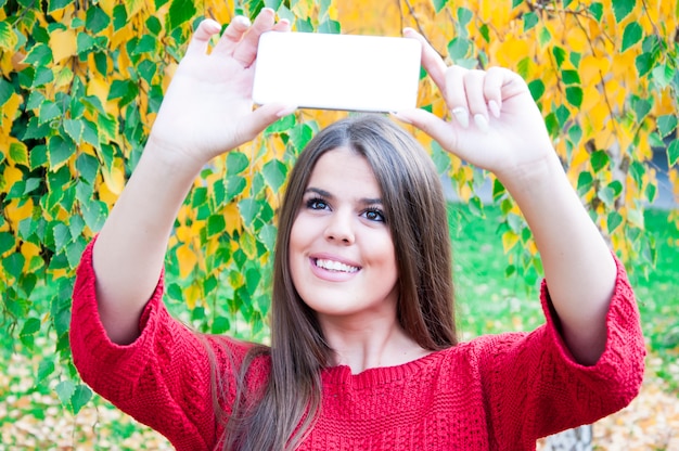 Ragazza carina in posa per selfie tra natura