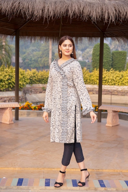 Cute Girl Posing with Attitude under a Hut in Park Wearing Traditional Stylish Dress for Photoshoot