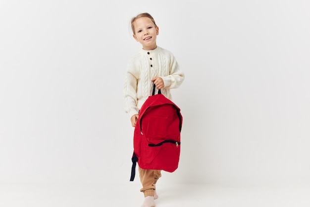 Cute girl school backpack with a hat on his head light background