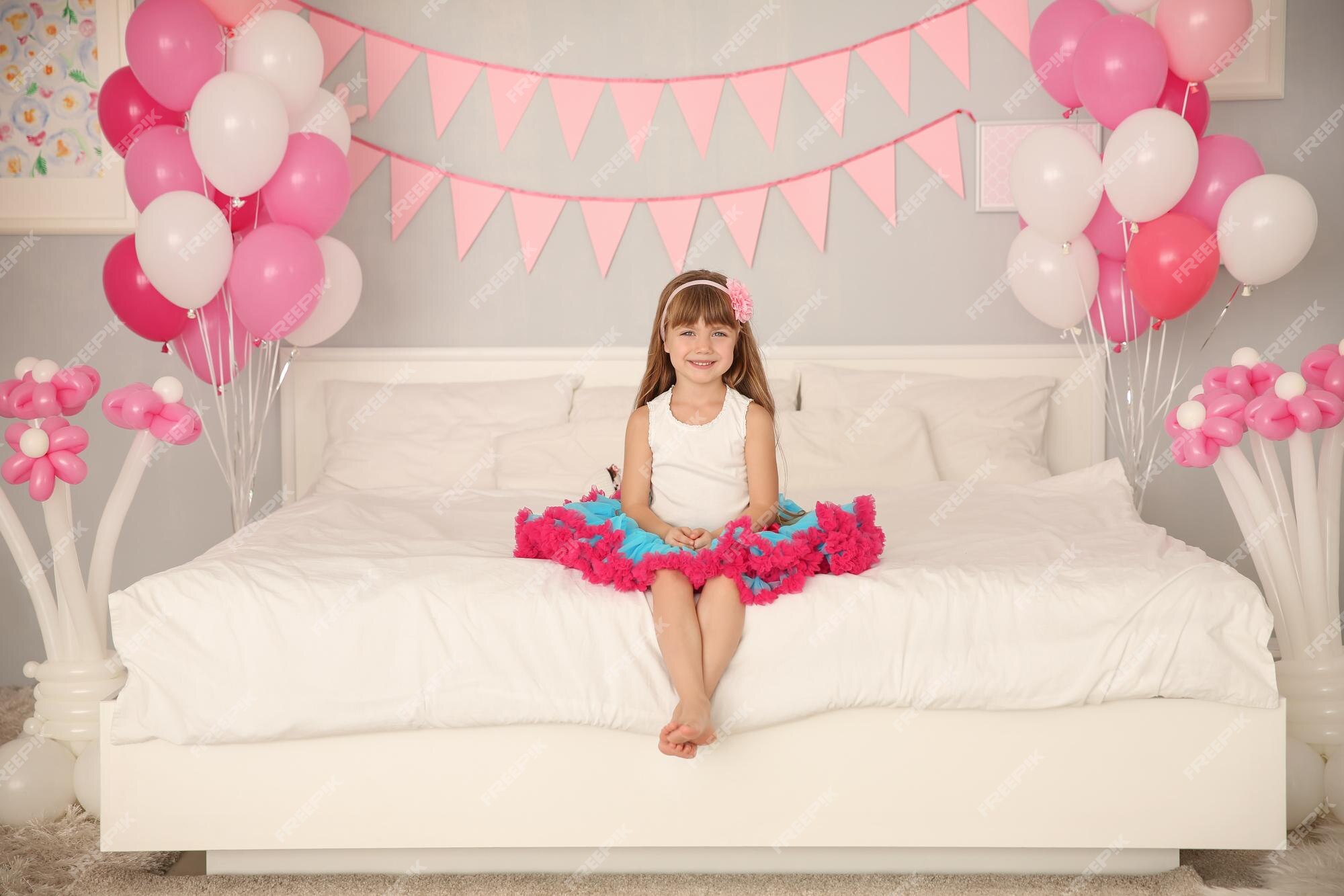 Premium Photo | Cute girl sitting on bed in room decorated for ...