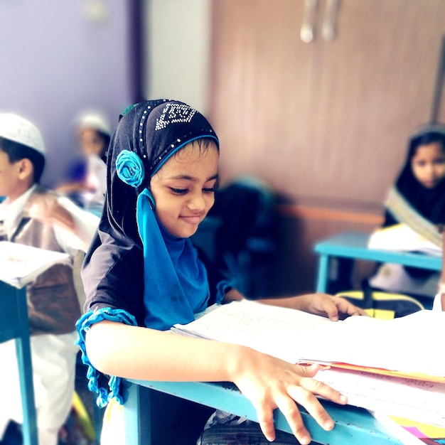 Photo cute girl sitting in classroom