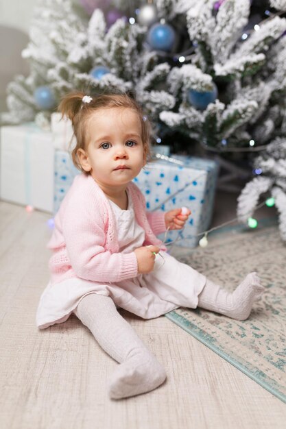 Photo cute girl sitting on floor at home during christmas