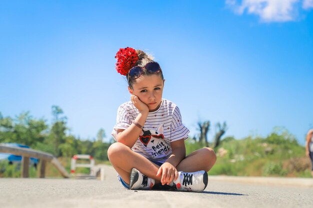 Photo cute girl sitting outdoors