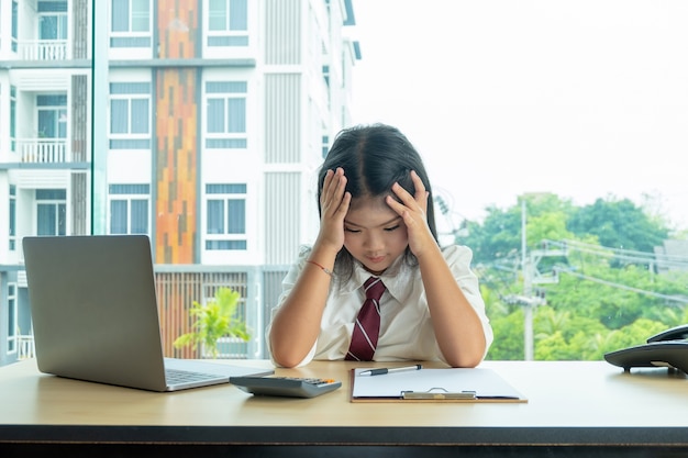 かわいい女の子が部屋に座って疲れて頭痛を感じる