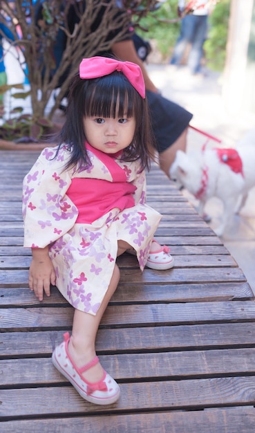 Cute girl sitting on wood