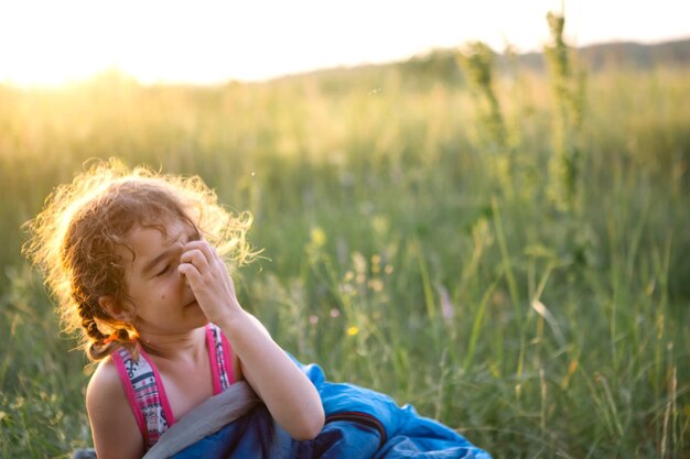 Photo cute girl in sleeping bag in field