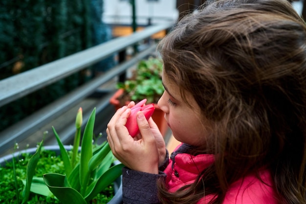 Cute girl smelling flower outdoors