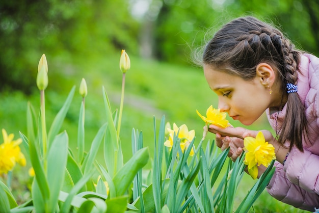 Foto ragazza carina odorando un fiore