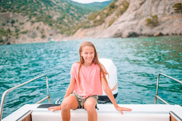 Cute girl smiling and enjoying sailing on boat in the open sea