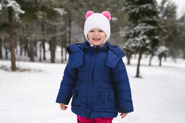 Una ragazza carina in una foresta innevata d'inverno