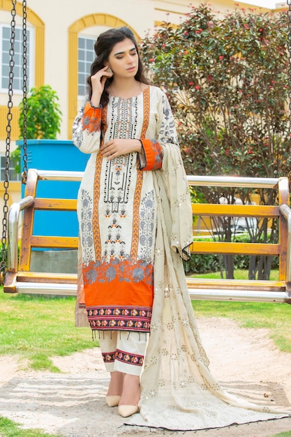 Cute Girl Standing in Garden with Blushing Pose near a bench Wearing Desi Dress for Fashion Shoot