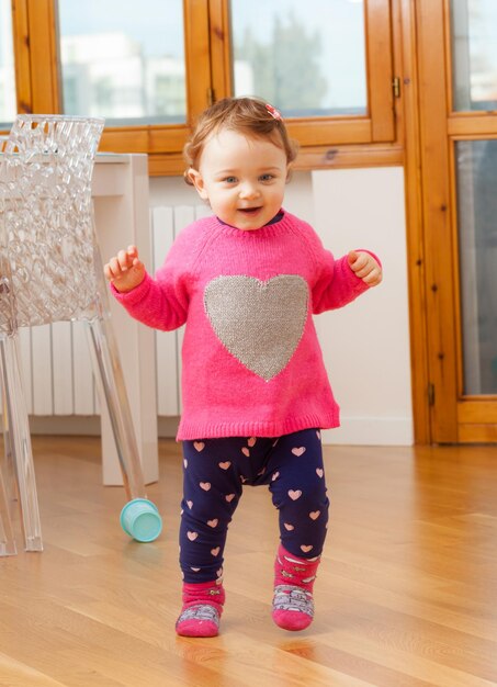 Photo cute girl standing on wooden floor at home