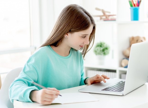 Cute girl studying with laptop, online education