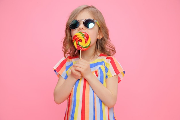 Photo cute girl in sunglasses with lollipop