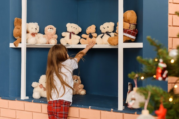 Cute girl in the teddy bear shop on Christmas Eve