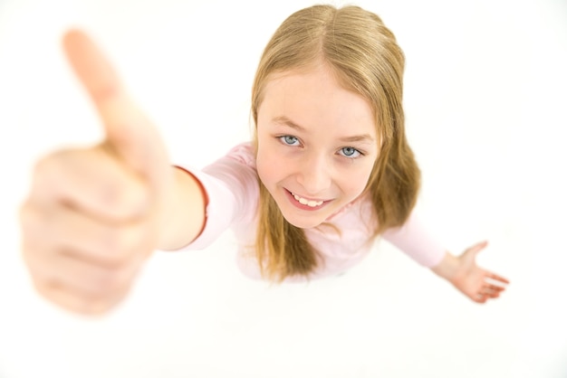 The cute girl thumbs up to the camera. View from above