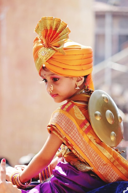 Cute girl in traditional clothes looking away