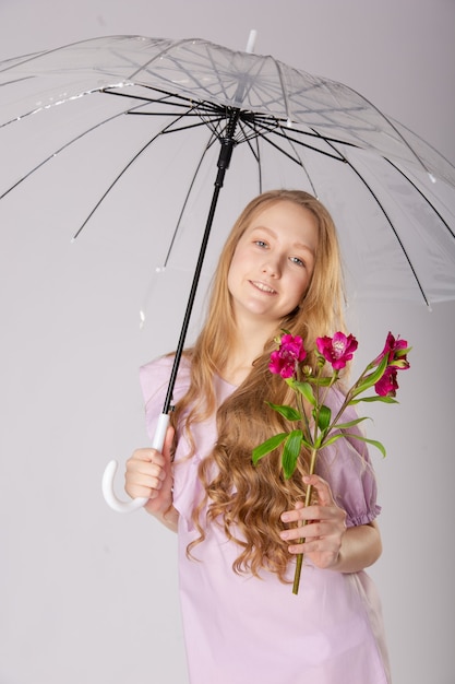 Cute girl under an umbrella with flowers