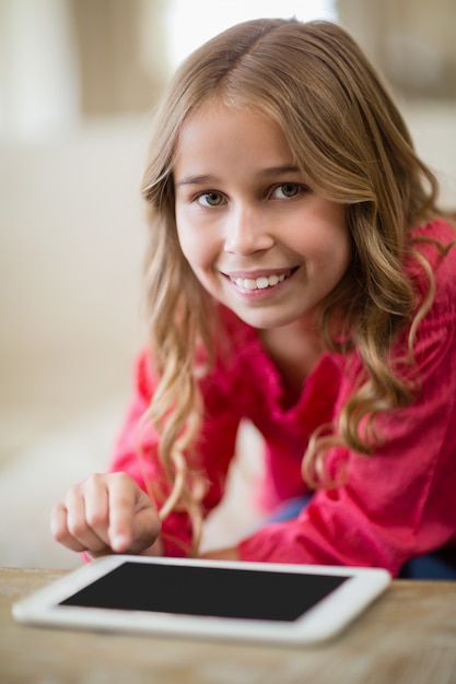 Cute girl using digital tablet in living room