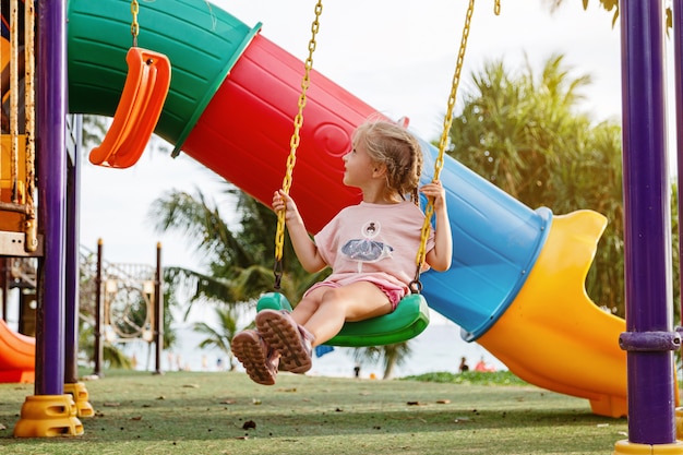 Cute girl walking outdoor on playground at summer