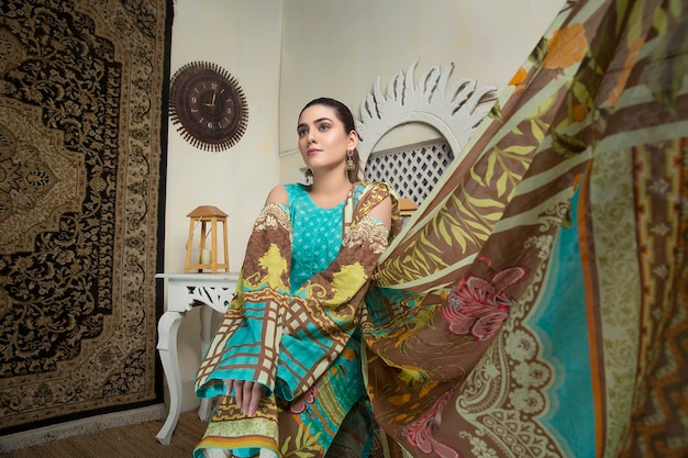 Photo cute girl waving dupatta landscape wearing desi floral dress for indoor shoot