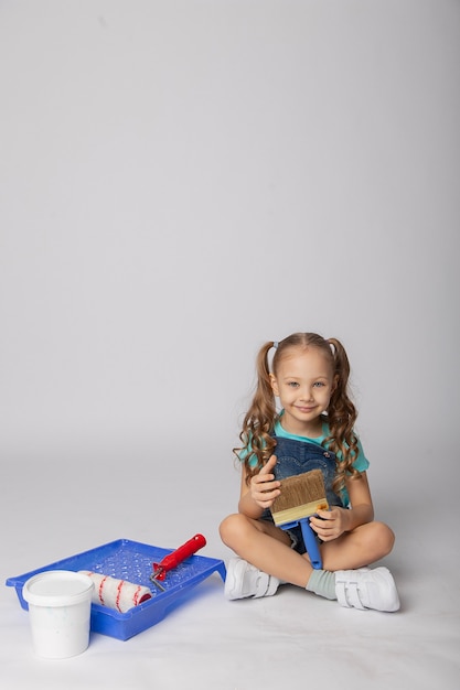 Cute girl on a white background with construction tools