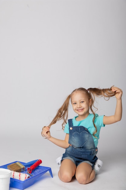 Cute girl on a white background with construction tools