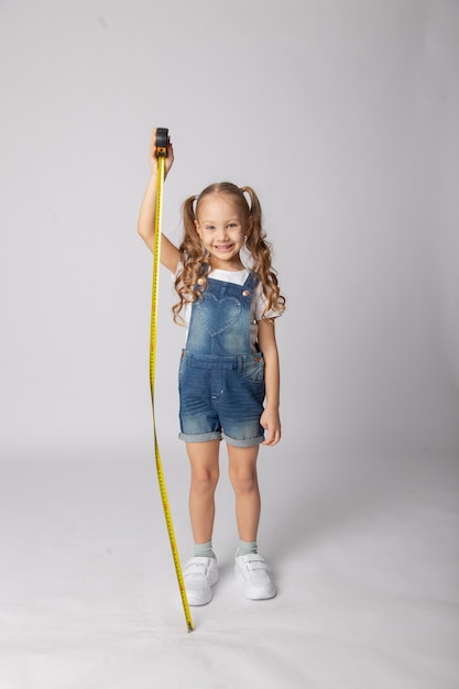 Cute girl on a white background with construction tools