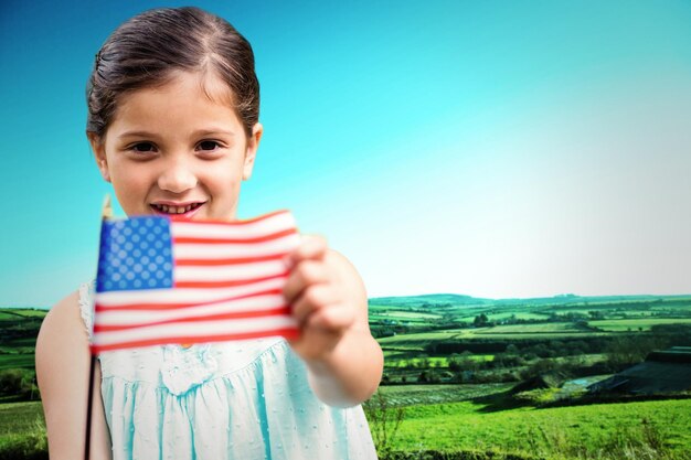 Милая девушка с американским флагом на фоне живописного пейзажа