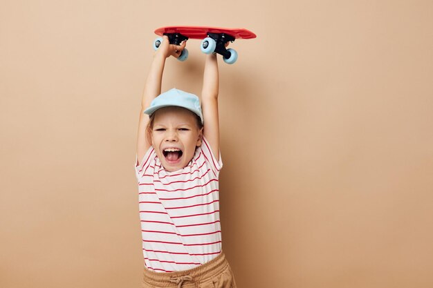 Cute girl with a children39s skateboard in hand smile Lifestyle unaltered