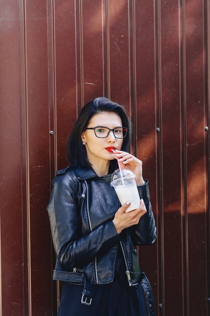 Ragazza carina con una bevanda fredda in giornata di sole