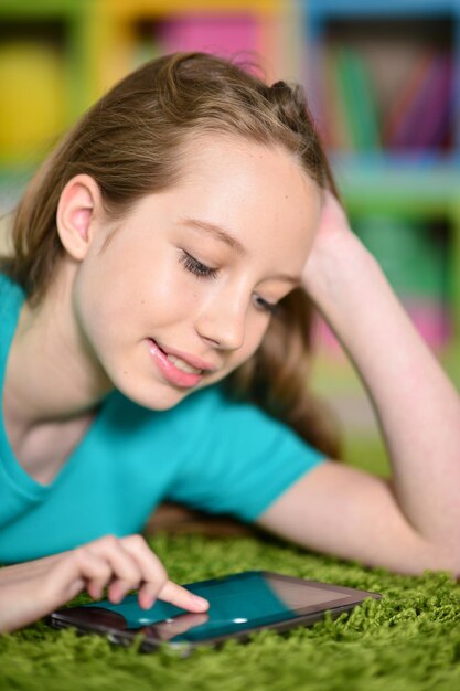 Cute girl with digital tablet on floor